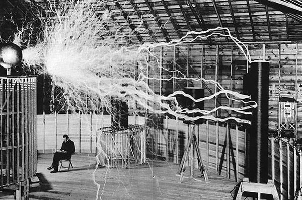 Nikola Tesla sitting in his laboratory with his "Magnifying Transmitter."