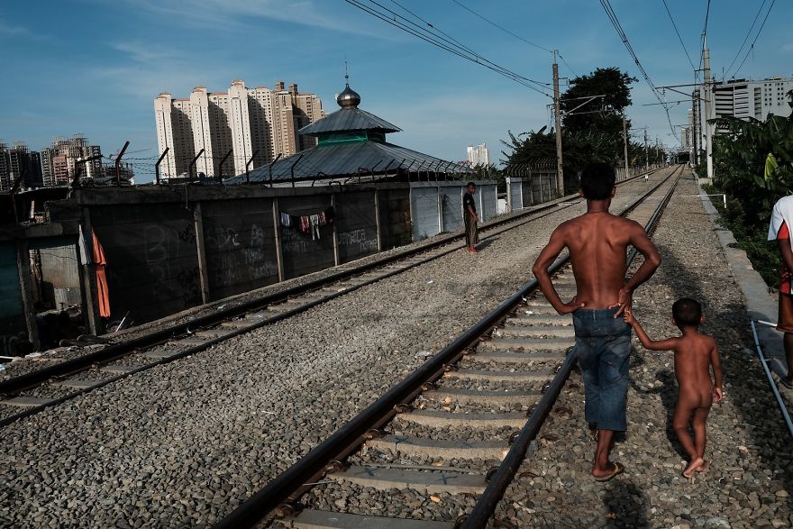 Father And Son Walking Along The Active Railway Tracks