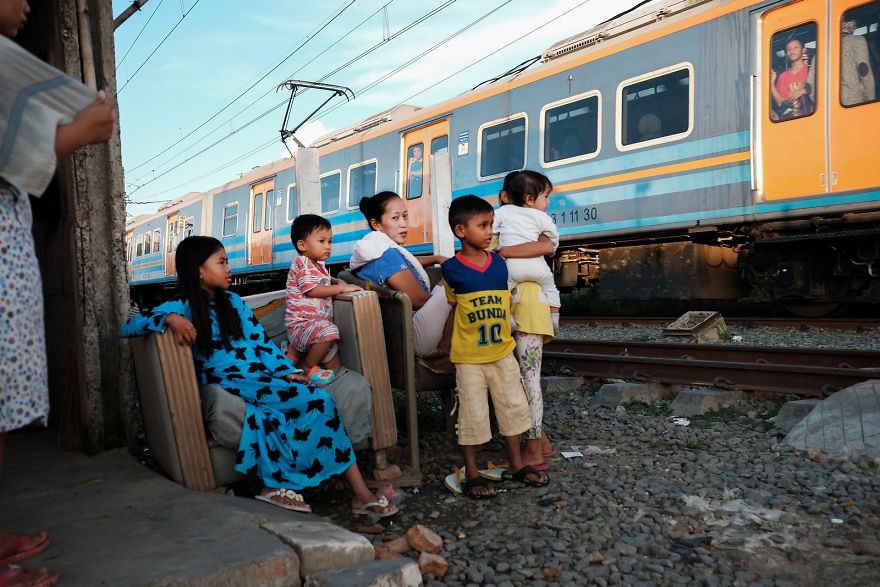 Family Is Watching The Train That Is Passing By Next To Their Home