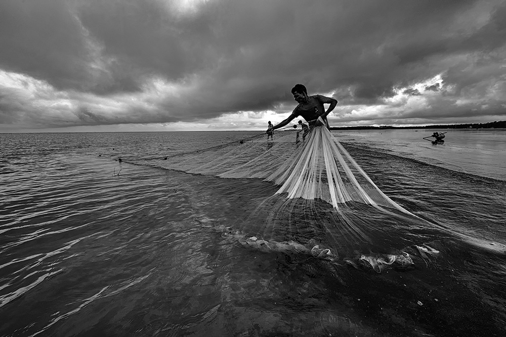 Fishermen in action on an overcast day in Udaypur beach, Odisha-West Bengal Border